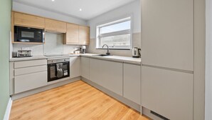 Una cocina moderna con microondas, tostadora, fregadero y hervidor.