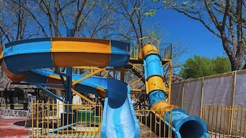 Parque acuático con piscina, toboganes y una estructura de juegos.