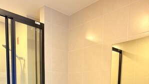 A bathroom with a glass shower enclosure, a toilet, and a sink. - Room-dcondo Reef Kathu Patong (Kathu)