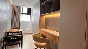 Ein modernes Interieur mit Essbereich, einem gebogenen Sessel und integrierten Regalen.