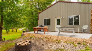 A building with a patio, a grill, and outdoor seating. - Cozy 1BR Lakefront Retreat on Rice Lake – Sleeps 6 | Fishing & Snowmobile Paradise (Spooner)