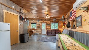 A rustic cabin interior with a kitchen, dining area, and living room. - Cozy 1BR Lakefront Retreat on Rice Lake – Sleeps 6 | Fishing & Snowmobile Paradise (Spooner)