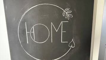 Una pizarra con la palabra 'HOME' escrita a tiza, rodeada por un círculo y un dibujo de una hoja.
