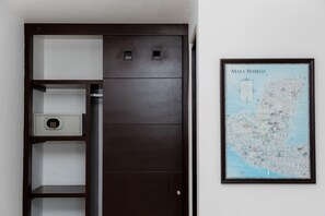 Ein dunkler Holzschrank mit einem kleinen Safe, eine Karte der Maya-Welt an der Wand und eine Tür mit Griff.