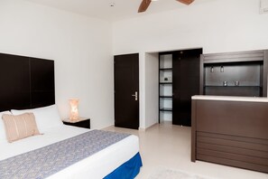 A bedroom with a bed, bedside table, nightstand, wardrobe, and built-in shelving unit. - Mojarra Marazul: Suite Boutique with Terrace in Cancún (Cancún)