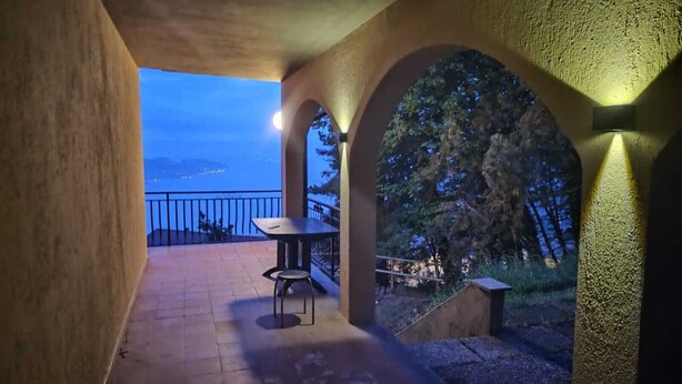 Eine Terrass mit Tisch und Stühlen, einem Geländer und Blick auf die Landschaft.