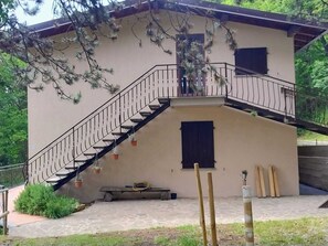 Ein zweistöckiges Gebäude mit Treppe, einer kleinen Bank und Baumaterialien.