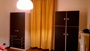 Een kamer met een kast, een bed en een gordijn.