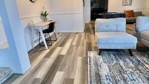 Ein modernes Wohnzimmer mit einer Couch, einem Esstisch mit Stühlen und einem gemusterten Teppich.