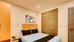 Ein Hotelzimmer mit Bett, Nachttisch und Telefon.