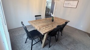 A dining area with a wooden table, black chairs, a chandelier, and a framed quote on the wall. - Countryside Home in Beautiful Aiken SC (Aiken)