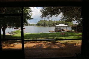 A view from a window overlooking a lake, a gazebo, and a grassy area with a dock. - ISLAND LAKE ESCAPE
3-bedroom house on spring fed Island Lake in Fort McCoy (Fort McCoy)