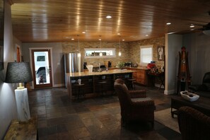 A spacious kitchen with a central island, wooden ceiling, and stone walls. - ISLAND LAKE ESCAPE
3-bedroom house on spring fed Island Lake in Fort McCoy (Fort McCoy)
