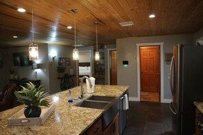 A kitchen with granite countertops, stainless steel appliances, wooden ceiling, and pendant lighting. - ISLAND LAKE ESCAPE
3-bedroom house on spring fed Island Lake in Fort McCoy (Fort McCoy)