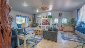 Una sala de estar acogedora con un sofá, una mesa de centro de madera, una chimenea y un gran tronco de árbol.