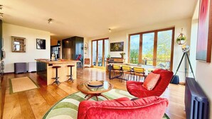 A spacious living area with a kitchen, dining area, and a large window providing a view. - Grand Chapel with Views in Peaceful Devon Hills (Devon)