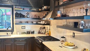 Une cuisine moderne avec des meubles de couleur sombre, un îlot central et une lucarne.
