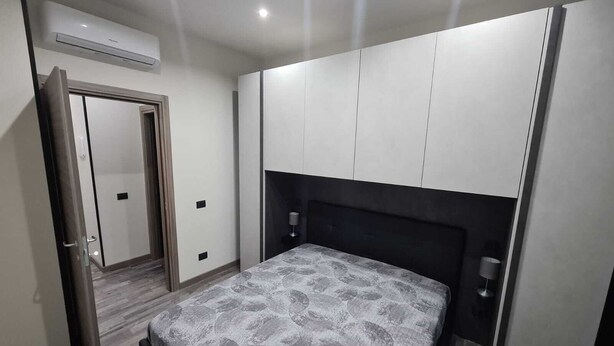 Una camera da letto con un letto, un armadio, una porta e un condizionatore.