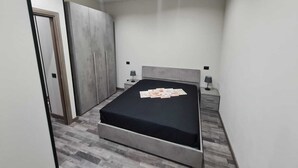 Una camera da letto moderna con un letto, comodini e un armadio.
