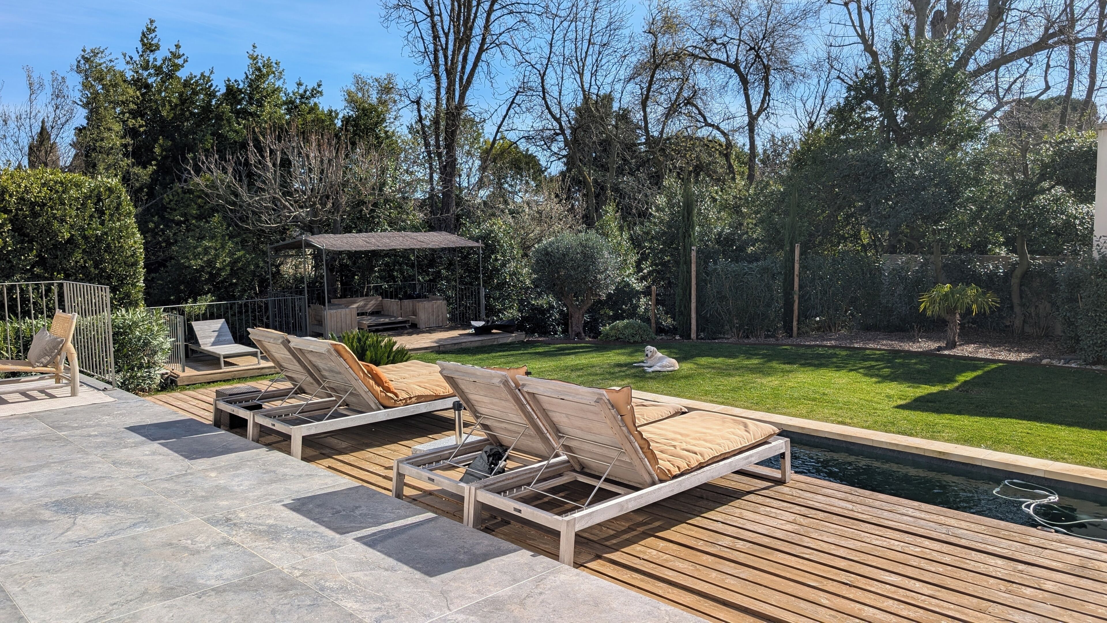 A deck with lounge chairs, a barbecue area, and a swimming pool.
