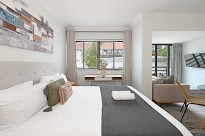 Ein Hotelzimmer mit Bett, Schreibtisch, Stuhl und Fernseher.