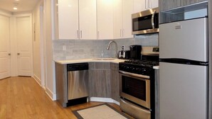 A modern kitchen with white cabinets, stainless steel appliances, and a dishwasher.