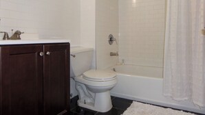 A bathroom with a toilet, sink, and bathtub.