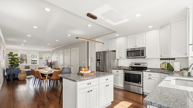 A modern kitchen with white cabinets, stainless steel appliances, and a granite countertop. - Spacious and furnished 4-bedroom in beautiful Washington, DC. (Washington)