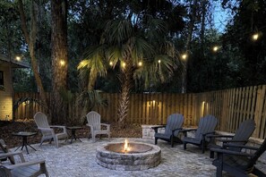 A patio area with a fire pit, outdoor seating, and string lights. - 4 Block Walk to UF O’Dome • Sleeps 9 • Fire Pit Yard Games • Parking for 6 Cars (Gainesville)