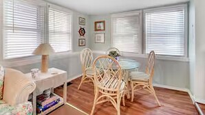 Una habitación con una mesa de comedor y sillas, un sofá y una lámpara.