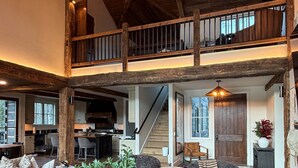 Un loft espaiós amb un sostre alt, bigues de fusta a la vista, zona de dinar i cuina.
