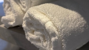 Rolled white towels stacked on a surface. - Areião Park Hotel (Goiânia)