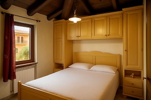 Una camera da letto con un letto in legno, una finestra vista e armadi a muro in legno.