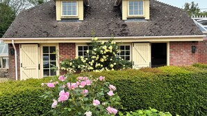 A two-story house with a brick facade, two dormer windows, and a front door. - New Barn (Salisbury)