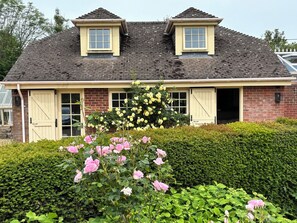 A two-story house with a brick facade, two dormer windows, and a front door. - New Barn (Salisbury)