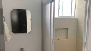 A bathroom with a pedestal sink, a mirror, and a glass-enclosed shower. - House with heated pool and 5 min from the pacific ocean (Mazatlán)