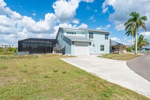 Ein zweistöckiges Haus mit Garage, überdachter Terrasse und Rasen.