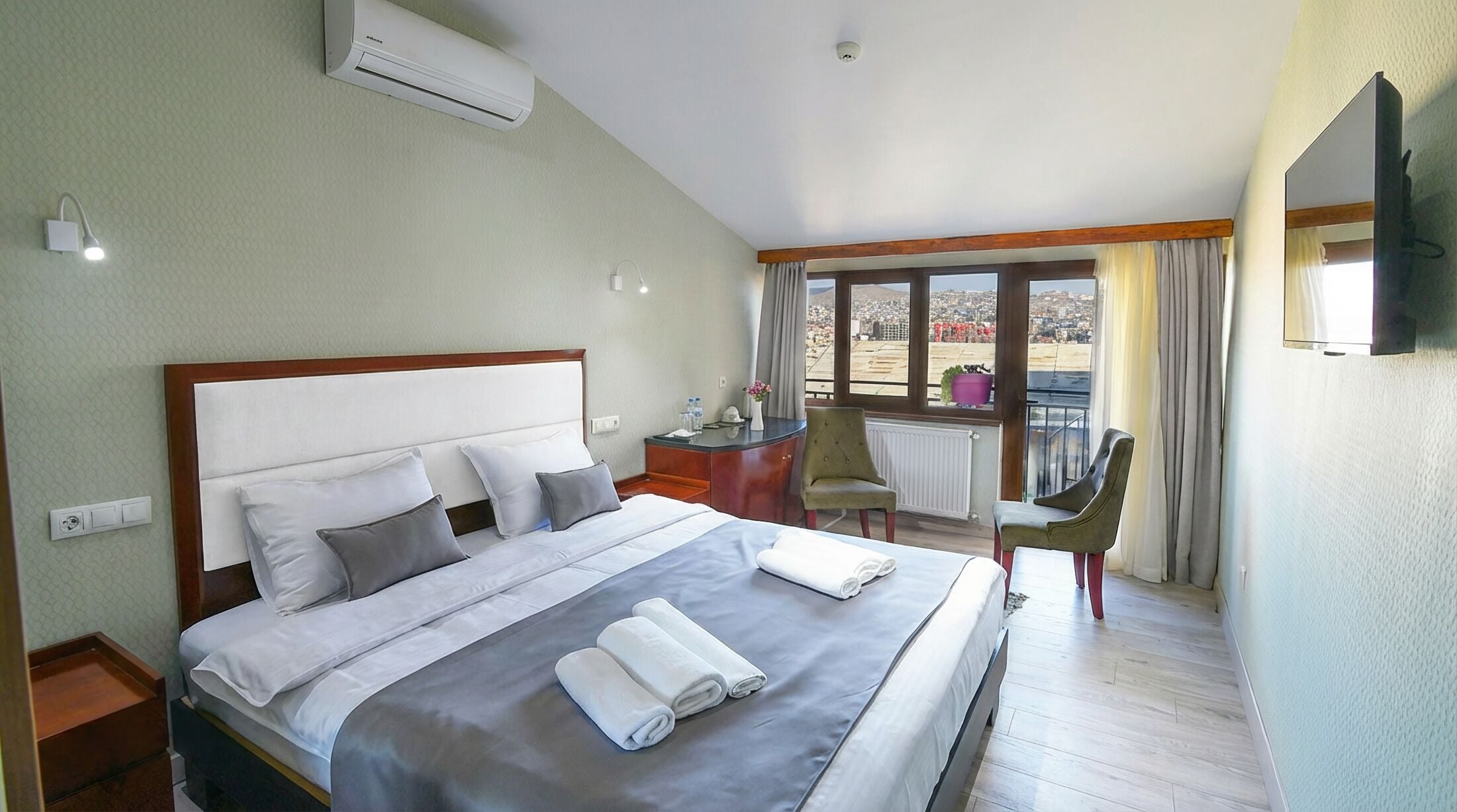 Una habitación de hotel con cama, escritorio, silla y televisión.
