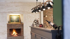 A fireplace with a visible fire, a shelf with decorative items, and a hanging light fixture.
