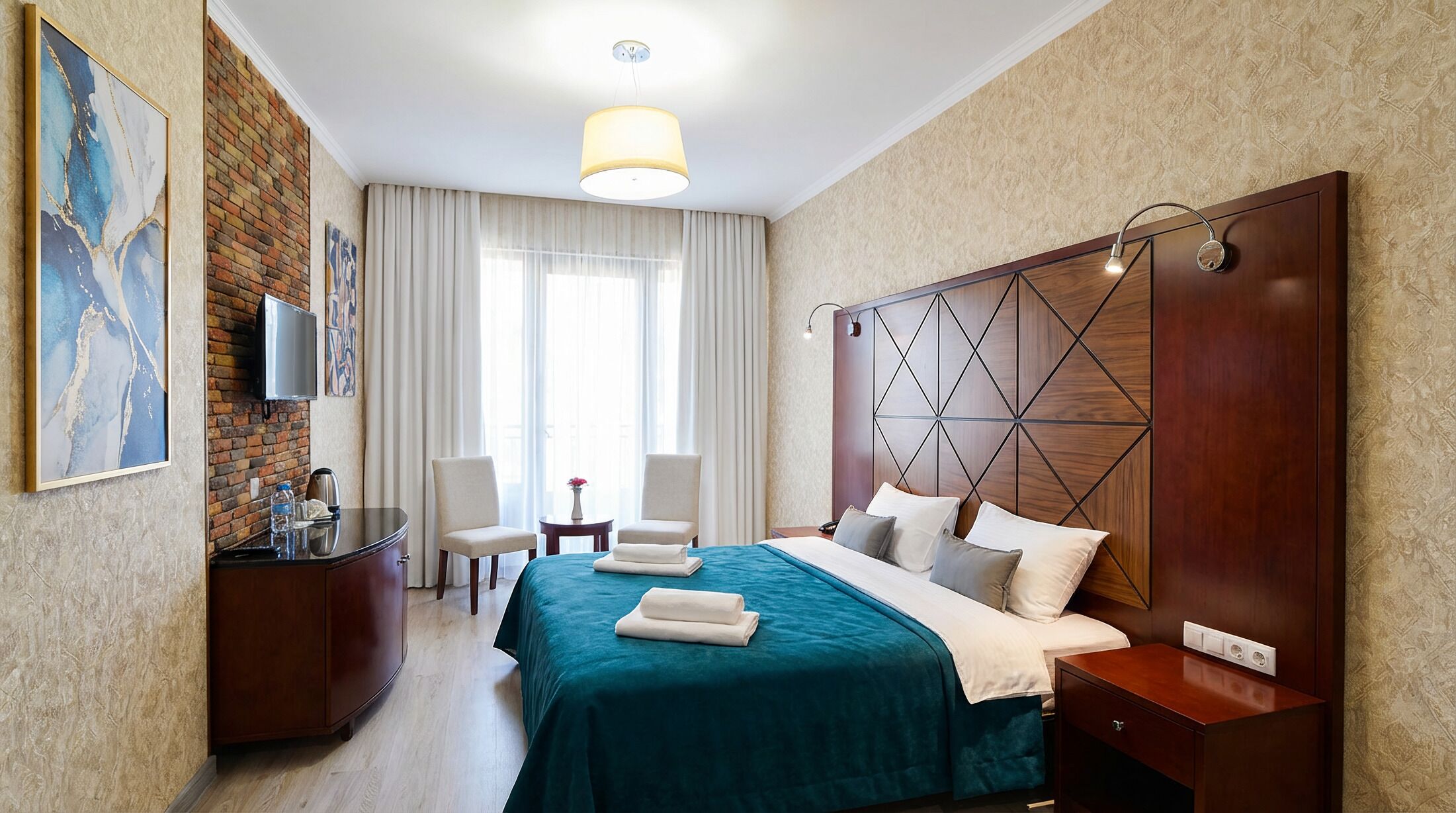 Een hotelkamer met een groot bed, een bureau, een stoel, een televisie en een raam met gordijnen.