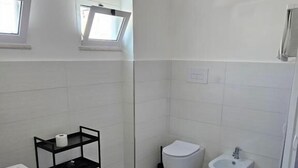 A bathroom with a toilet, bidet, and sink. - Onda Blu (Agropoli)