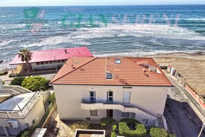 Ein Küstengebäude mit rotem Ziegeldach, einem Balkon und Meerblick.