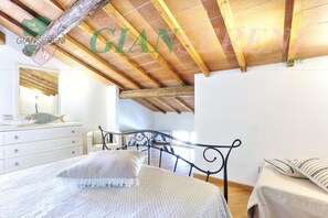 Ein Schlafzimmer mit Bett, Schminktisch und Fenster.