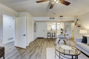 A spacious living area with a dining table, a sofa, and a ceiling fan. - Ground Floor, Walk to Beach, Pool, Port Royal Village, Golf View (Hilton Head Island)
