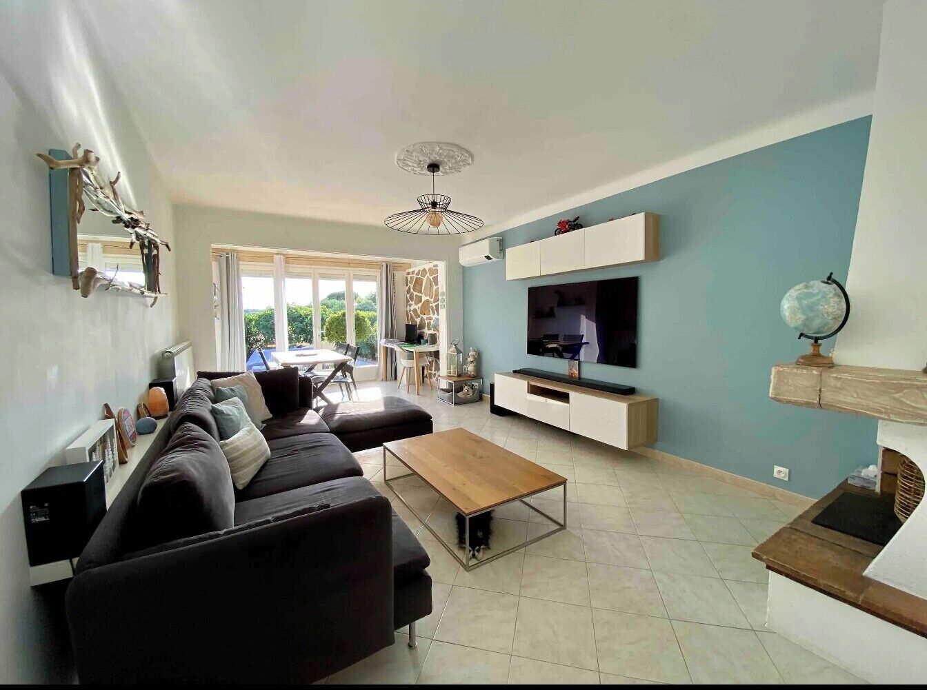 A modern living room with a sofa, coffee table, TV, and a fireplace.