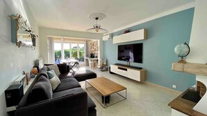 A modern living room with a sofa, coffee table, TV, and a fireplace. - Comfortable house in a quiet location close to the beach (Puget-sur-Argens)