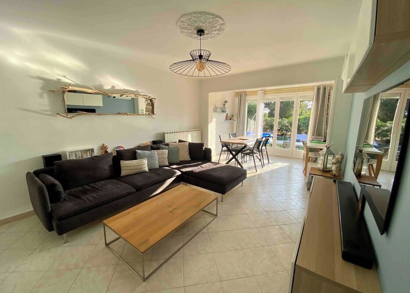 Un salon moderne comprenant un canapé, une table basse et un coin repas avec une table et des chaises.