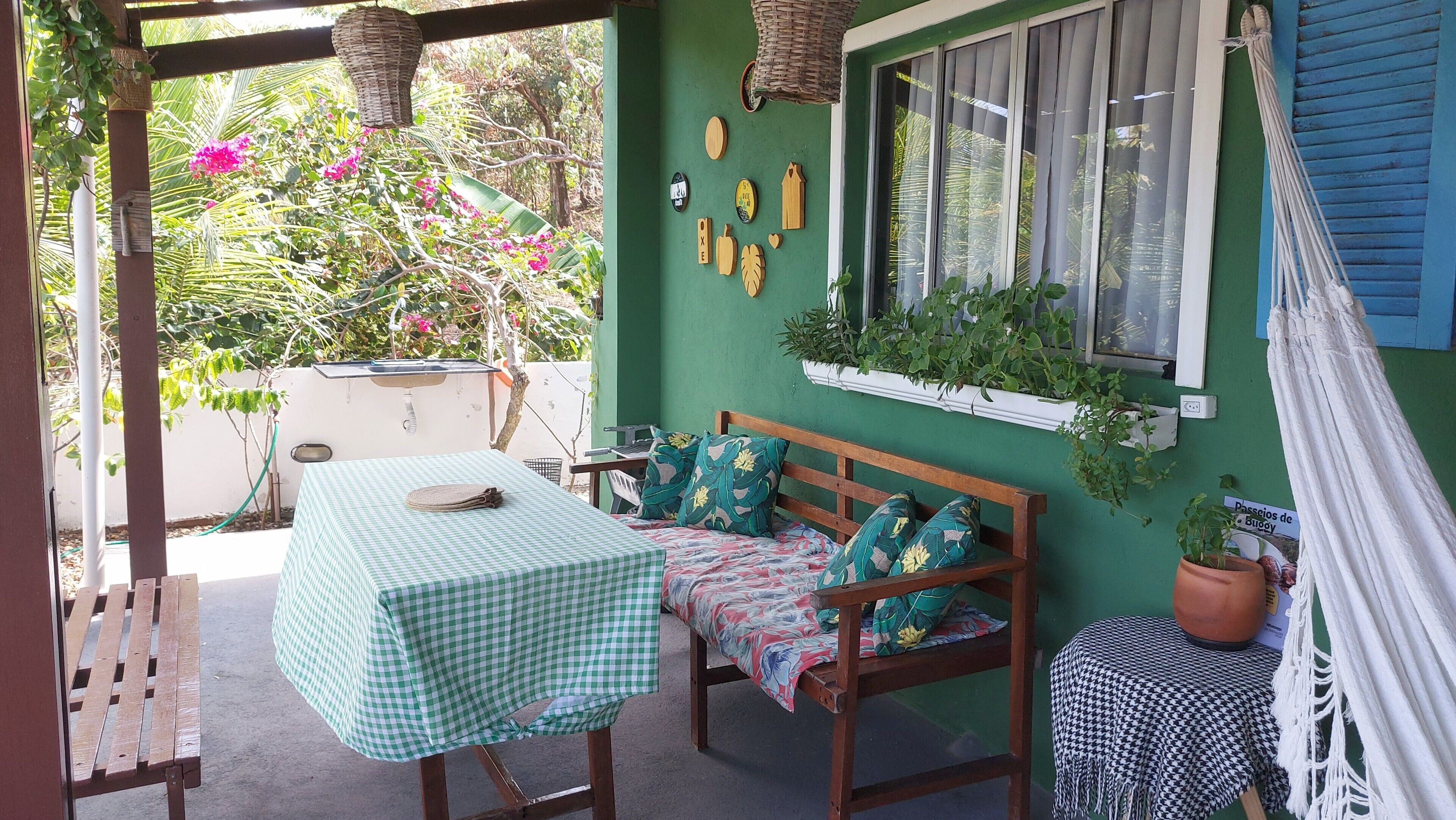 A patio with a checkered table, wooden bench, and potted plants.