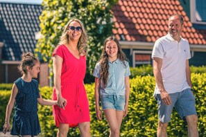Una familia caminando al aire libre, con un edificio en el fondo.