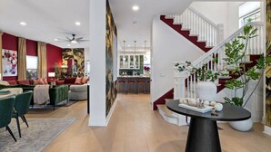 A spacious living area with a staircase, a dining area, and a kitchen in the background. - Mt. Washington Marvel. Stunning New Design, Epic Views, Hot Tub, Parking (Pittsburgh)